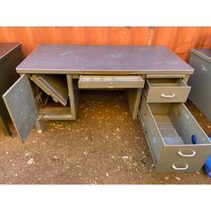 an old metal desk with two drawers on top and one open drawer in the middle