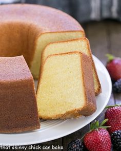 a bundt cake with three slices cut out on a plate next to some berries