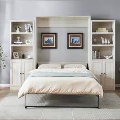 a white bed sitting in a bedroom next to a book shelf