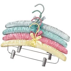 five different colored hair clips on a metal rack with a bow tied to it's end