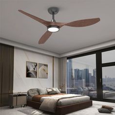 a bedroom with a bed, ceiling fan and large window overlooking cityscape in the background