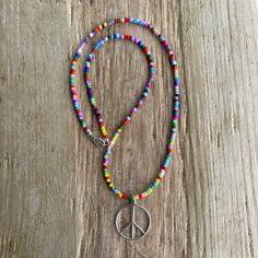 Spread good vibes wherever you go with this delightful peace sign necklace, handmade just for you.  Crafted from gleaming sterling silver, the peace sign pendant hangs from a vibrant 16" necklace strung with colorful hippie love beads.  Imagine yourself at a music festival, bathed in sunshine and positive energy, with this groovy necklace adorning your outfit! 925 Sterling Silver Peace Sign Pendant 16" Hippie Love Beads Necklace ~ The beads are tiny glass beads 1.5mm in diameter 925 Sterling Silver Lobster Clasp and Ring Handmade in Texas, USA Thoughtfully packaged in a signature kraft jewelry box ready to gift Peace Sign Jewelry Diy, Bohemian Peace Sign Necklace For Gift, Bohemian Silver Jewelry With Letter Beads, Silver Bohemian Jewelry With Letter Beads, Hippie Jewelry With Tiny Beads For Gifting, Adjustable Peace Sign Necklace As Gift, Adjustable Peace Sign Necklace, Hippie Jewelry With Tiny Beads For Gift, Spiritual Peace Sign Necklace As A Gift