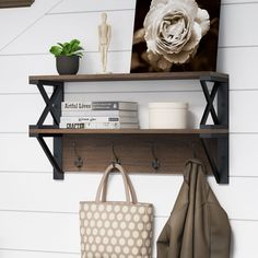 a wooden shelf with two hooks and a bag on it next to a wall mounted bookcase