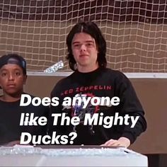 two people standing next to each other in front of a soccer net with the words does anyone like the mighty ducks?