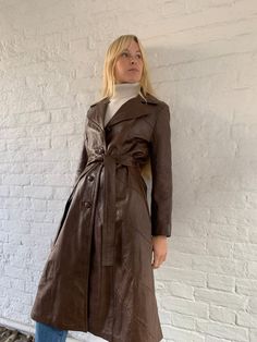 Elevate your autumn/fall wardrobe with our Women's Long Coat Trench Coat. Inspired by vintage 80s fashion, this Brown Vintage Double-Breasted Belted Maxi Leather Jacket adds a touch of timeless elegance to any outfit. Crafted with high-quality materials, this fashion-forward trench jacket combines classic design with modern flair. Perfect for layering over your favorite autumn ensembles, this belted coat effortlessly enhances your seasonal style while keeping you cozy and chic. Shop now to add t Modern 70s Fashion, 70s Trench Coat, Women Long Coat, Vintage Fashion 80s, Classic Trench Coat, Long Coat Women, Fall 24, Chic Shop, Trench Jacket