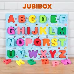 colorful magnetic letters and numbers on a wooden surface with the words jumbox above them