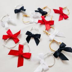 These elegant ribbon bow earrings are perfect for adding a touch of fun to your night. The most adorable bow dangle earrings perfect for the holiday season or a great bridesmaid gift! Available in three colors white, black or red and each bow is handmade with silky soft satin ribbon. Hoops are 14 karat gold plated or sterling silver plated hoop are hypoallergenic and nickel free Hoops are 1 inch in total diameter and 1 1/2 inches in total length with the bow.  Christmas Earrings, Christmas Gift Unique Wedding Veils, Christmas Gift Bow, Halloween Themed Wedding, Rhinestone Hair Pin, Mini Bow, Tiny Bow, Bow Christmas, Napkin Design, Handmade Gifts For Her