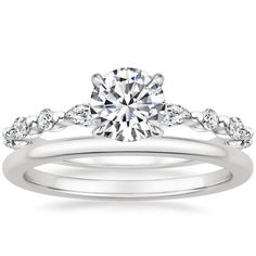 a white gold engagement ring set with diamonds on the band and a round cut diamond in the center