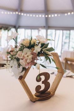 the table numbers are made out of wood and have flowers in them