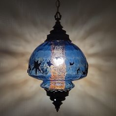 a blue glass light hanging from a ceiling