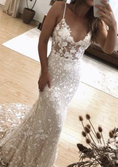 a woman is taking a selfie in her wedding dress while standing on the floor