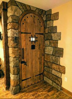 a large wooden door sitting inside of a stone wall