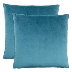 two blue velvet pillows sitting on top of each other