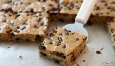 chocolate chip cookie bars on a baking sheet with a spatula