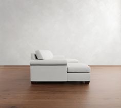 a white couch sitting on top of a wooden floor