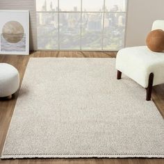 a white rug in a living room with a chair and footstool on the floor