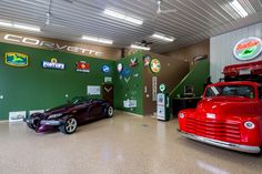 two cars are parked in a garage with signs on the wall