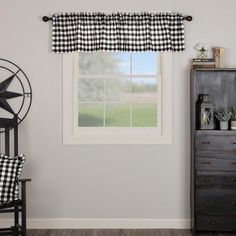 a black and white checkered valance hangs over a window