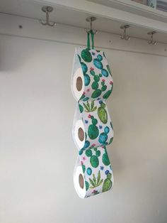 three rolls of toilet paper are hanging on the wall next to each other with cactus designs