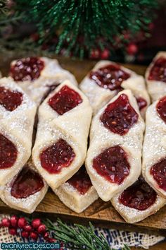 several pastries are arranged on a cutting board next to a christmas tree and pine cones