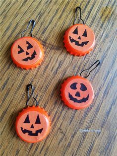 three orange bottle caps with jack o lantern faces on them