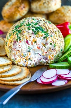 a cheese ball on a plate with crackers and radishes