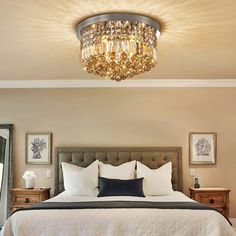 a bedroom with a large bed and a chandelier hanging from it's ceiling