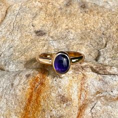 This is a very simple yet stunning 14k gold ring, featuring an intense deep purplish blue tanzanite cabochon.  It is bezel set, and closed back. The shank is a simple half round gold strip. This is a beautiful and solid ring. This ring is size 8 1/4 Thank you for looking! Classic Oval Cabochon Sapphire Ring With Bezel Setting, Classic Sapphire Ring With Oval Cabochon Bezel Setting, Classic 14k Gold Sapphire Oval Cabochon Ring, Fine Jewelry 14k Gold Sapphire Ring With Oval Cabochon, Yellow Gold Sapphire Ring With Bezel Setting, Oval Cabochon, 14k Gold Sapphire Ring Oval Cabochon, Oval Cabochon Amethyst Ring, Oval Tanzanite Cabochon Jewelry, Oval Cabochon Tanzanite Jewelry