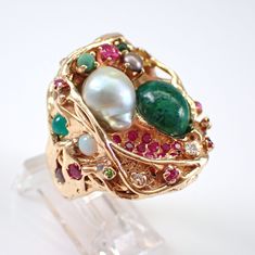 "Vintage Solid 14k Yellow Gold Baroque Pearl and Jade Cluster Ring. This ring is set with two main gemstones that include a Baroque Pearl and an Oval Cabochon Jade.  The ring is set with multi color gemstones throughout.  These gems include Diamonds, Rubies, Emeralds, Rhodolite Garnets, Opal, Sapphires and Citrine.  All the gemstones are genuine and set in an abstract design. This ring weighs 28.6 grams, measures 27 mm along the finger (a little over 1\") and is a finger size 5 1/2, which can be Collectible Green Multi-stone Jewelry, Unique Multi-stone Emerald Jewelry, Fine Jewelry Emerald Multi-stone, Fine Jewelry Emerald With Multi-stones, Fusion Multi-stone Jewelry For Anniversary, Unique Multi-stone Emerald Ring, Unique Multi-stone Emerald Ring For Formal Occasions, Fusion Style Multi-stone Jewelry For Anniversary, Heirloom Multi-stone May Birthstone Jewelry