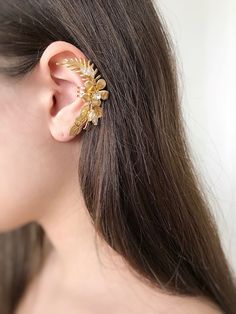 Gorgeous modern style ear cuff decorated with delicately shaped leaves. You can use our ear cuff on the right or left side.  Has a rode metal soldered on the back of it that could be  opened for an easy wear or squeezed inwards for a secure fit. The set includes a mini zirconium stud earring for the second ear VAT: Value Added Tax (VAT) is a tax that is charged when your parcel reaches the destination country. You may be required to pay VAT in order to receive your parcel. Customs policies and import duties vary widely from country to country, and we have no control over these charges. As a guide: USA: from 800 USD UK: 20% EU: 15% CUSTOM ORDERS If you liked the product, but you want to make your own changes, color / length / use of other beads. Please tell me about it in a personal message Adjustable Gold Pierced Ear Cuff, Gold Pierced Ear Cuff For Party, Gold Delicate Pierced Ear Cuff, Delicate Gold Pierced Ear Cuff, Delicate Gold Pierced Ear Climbers, Gold Ear Cuff For Pierced Ears For Party, Delicate Gold Ear Climbers, Adjustable Gold Cartilage Earrings For Party, Elegant Gold Plated Cartilage Earrings For Wedding