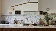 a kitchen with marble counter tops and brass accents