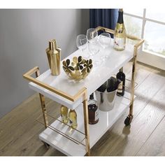 Host guests with panaches and style with the serving cart. This bar cart is perfect for serving guests, hosting parties, or just having a place to store an attractive cocktail setup. Two-tiers provide plenty of room for beverage prep and glassware storage. Dual bottle caddies keep wine bottles safe from tipping while rolling smoothly to where the action is. The ultra-luxe and modern gold-plate frame adds a sophisticated design element, and the high-gloss laminate cleans up with just a wipe. Lock New Orleans Apartment, Hosting Parties, Gold Bar Cart, Floating Bed Frame, Linen Headboard, Velvet Upholstered Bed, Brown Chair, Glassware Storage, Serving Cart