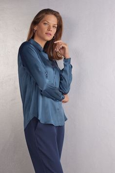 Long sleeve shirt in light stretch silk with collar and buttons up the middle. Back yoke with pleat for a draped, loose fit. Buttoned cuffs and rounded hem. Elegant Shirt With Roll-up Sleeves And Spread Collar, Elegant Business Casual Blouse With Rolled Sleeves, Elegant Blue Tops With Button Cuffs, Elegant Blue Top With Button Cuffs, Elegant Blouse With Rolled Sleeves For Fall, Elegant Blouse With Rolled Sleeves For Business Casual, Elegant Fall Blouse With Rolled Sleeves, Chic Blue Blouse With Spread Collar, Chic Blue Top With Cuffed Sleeves