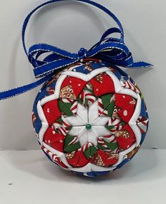 a red, white and blue ornament with candy canes on it's side