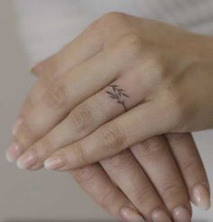 a woman's hand with a small tattoo on it