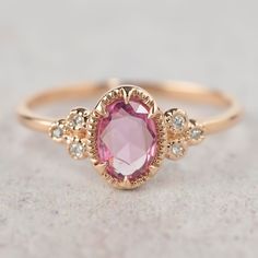 a close up view of a pink ring with diamonds