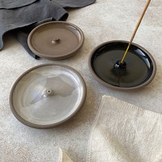 two bowls with sticks in them sitting on the floor next to some towels and cloths