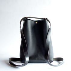 This convertible backpack, the Crossback 3-in-1 Bag, is as beautiful as is practical! Convert from shoulder or crossbody to a backpack with this one bag!Black LeatherBlack Leather StrapsBrass Hardware ... • Fast & FREE Shipping on orders over $150• Made with a single piece of Full-Grain leather• Snap button closure• Button studs on each side to add support as a crossbody bag• Top extender• Open interior pocket• Measurements: 14" wide across top, 11” wide across bottom, 15" high, 5" deep• Handle Minimalist Bucket Bag With Detachable Handle For Travel, Minimalist Leather Backpack With Adjustable Strap For On-the-go, Minimalist Leather Backpack With Adjustable Strap, Modern Bucket Bag Backpack With Detachable Strap, Minimalist Leather Backpack With Adjustable Strap For Everyday Use, Minimalist Bucket Bag With Adjustable Strap For Travel, Minimalist Crossbody Bucket Bag For Travel, Modern Bucket Backpack Bag For Everyday Use, Modern Leather Crossbody Backpack For Everyday