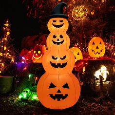 a group of pumpkins that are sitting in the grass with lights on behind them