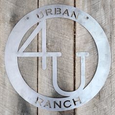 a metal sign that reads urban 4 u ranch on it's side against a wooden wall