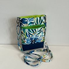 "Cross body phone bag in pretty flowery blues/greens by designer Moda fabrics. This is the perfect hands-free phone bag, for people on the go! Spacious interior (fits an iPhone 13Plus) with an extra outer zipper pouch to store your keys, money, or cards. The adjustable strap allows you to decide how close to your body you wish to wear it.  Great for when you need something simple to keep your items, while out walking the dog, taking your kids to school/events, travelling, rushing off to the gym Blue Phone Bag With Cell Phone Pocket For On-the-go, Green Pouch Phone Bag, Green Phone Bag With Removable Pouch For Travel, Green Phone Bag With Cell Phone Pocket For On-the-go, Green Pouch Phone Bag For Travel, Green Travel Pouch Phone Bag, Green Crossbody Phone Bag With Cell Phone Pocket, Perfect Hands, Crossbody Phone Bag