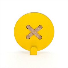 a yellow object with two crossed sticks on it's side, sitting in front of a white background