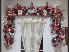 a window decorated with red and silver ornaments, christmas decorations, and candy canes