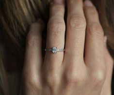 a woman's hand with a diamond ring on it