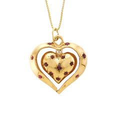 "This charming 14k yellow gold and Ruby pendant features two articulating hearts, both fashioned into a dome with a solid flat back. The inside heart is bead set with eight round Rubies; the inside heart dangles inside the center of the larger open heart, which has six bead-set, round Rubies. Perfect sentimental gift for your heart throb!   -  14k yellow gold  -  Outer Heart (frame): 1.13\" x 1.03\" x .17\" (28.80 wide x 26.30 long x 4.50mm deep) -  Inside Heart: .70\" x .63\" x .23\" (18.00 wide x 16.00 long x 5.80mm deep) -  Rubies: 14/0.03 to 0.06ct each, 0.62ctw (estimated due to mounting) -  Ruby color: Medium dark, very slightly brownish, slightly purplish red (slpR 6/3).  -  18\" Box Chain: 14k yellow gold (stamped), spring ring closure, .90mm wide  -  Total Weight: 10.34 grams comp Yellow Gold Heirloom Jewelry With Heart Charm, Heirloom Yellow Gold Jewelry With Heart Charm, Heirloom 14k Gold Heart Jewelry, 14k Stamped Double Heart Jewelry For Valentine's Day, Double Heart Charms Jewelry For Keepsake, Double Heart Charms Keepsake Jewelry, Double Heart Keepsake Charms Jewelry, Heirloom Heart-shaped Yellow Gold Jewelry, Valentine's Day 14k Stamped Double Heart Jewelry