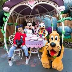 two children sitting at a table with goofy and minnie mouse