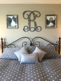 a bed with two pictures on the wall above it and one has polka dot pillows