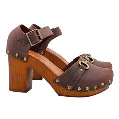 CLOGS HANDMADE IN ITALY Dutch style clogs with brown wood effect base Brown upper with golden accessory Closed rounded tip Adjustable ankle strap Padded leather insole Heel height 9cm with 2.5cm plateau Entirely made by specialized Italian personnel Handcrafted using the best materials. BEFORE COMPLETING YOUR PURCHASE DO NOT FORGET TO CHECK THE SIZE! Brown High Heel Clogs With Reinforced Heel, Brown Open Toe Wooden Clogs, Brown Wooden Clogs With Wooden Heel, Brown High Heel Platform Clogs, Denim Mules, Brown High Heel Clogs With 4-inch Heel, Style Clogs, Dutch Clogs, Dutch Style