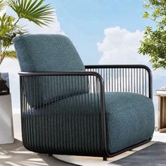 a chair sitting on top of a cement floor next to a planter and potted palm tree