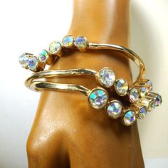 "Trashy Rhinestone Bangles, Lot of 3 Identical Goldtone Stacking Bracelets, Aurora Borealis Glass Stones, Wear 1 or 2 Or 3, Glam Glitz and fancy This listing is 3 exactly the same great bangle bracelets to wear separate or together, fancy rainbow glass stones on gold shiny metal all fit normal size wrists 7 1/4\" inner circumference ( 18.41cm ) 2 1/2\" across ( 6.35cm ) -----------------------------. ------ PLEASE NOTE I ONLY ship to your paid Etsy invoice ADDRESS I combine all shipping and refu Adjustable Sparkling Crystal Bangle Bracelet, Adjustable Gold Crystal Bracelet With Jewels, Gold Crystal Bracelet With Jewels, Adjustable, Adjustable Dazzling Crystal Bangle Bracelet, Adjustable Dazzling Crystal Bangle, Adjustable Gold Crystal Bracelet With Rhinestones, Gold Crystal Bracelet With Stones For Party, Gold Crystal Bracelet Costume Jewelry, Gold Crystal Bracelet With Rhinestones, Adjustable